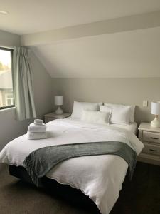 1 dormitorio con 1 cama blanca grande y ventana en Stylish Oasis in central city en Christchurch