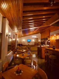 un ristorante con soffitti e tavoli in legno e sedie di Milionis Forest Hotel a Grevena