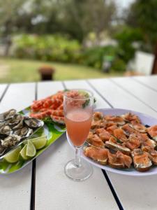 a plate of food and a drink on a table at SHELLHARBOUR BEACH COTTAGE ---- Back gate onto Beach, Front gate walk to Marina in Shellharbour