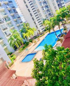 einen Pool mit Palmen und Gebäuden in der Unterkunft One Palm Tree Villas Condo Across NAIA Terminal 3 in Manila