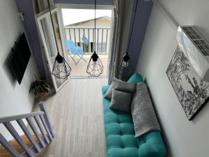 sala de estar con sofá azul y escalera en Papangue en Saint-Denis