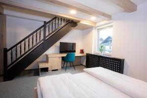 - une chambre avec un lit, un bureau et un escalier dans l'établissement Rooms Bolero Naklo, à Naklo