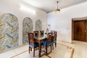 ジャイプールにある2 Bedroom Villa with Terrace - Child Friendly Wifi by Vacation Podのダイニングルーム(テーブル、椅子付)、壁画