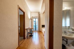 Habitación con baño con lavabo y mesa. en Hotel Nuova Grosseto, en Grosseto