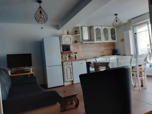 een keuken en een woonkamer met witte apparatuur en een televisie bij Au cœur de Pornic in Pornic