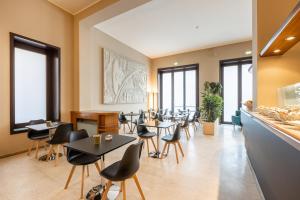 Un restaurante con mesas, sillas y ventanas. en Hotel Nuova Grosseto, en Grosseto