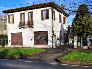 una casa bianca con due porte del garage su una strada di Noemi Venice Home a Marghera