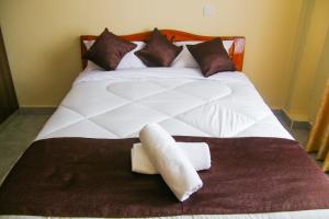 A bed or beds in a room at Lux Suites Milimani Luxe Apartments kisumu