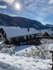 ein Haus mit schneebedecktem Dach im Schnee in der Unterkunft Enrosadira in Molveno