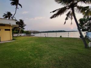 a view of the water from a house with a palm tree at Wind &Waves in Kollam