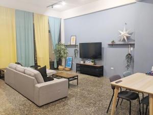 ein Wohnzimmer mit Sofa und Fernseher in der Unterkunft 舟津食旅 Mooring B&B 禁菸民宿 訂房請詳閱住宿須知 in Hualien