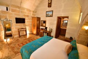 a bedroom with a large bed in a room at NOSTALJİ CAVE SUİT HOTEL in Nevşehir
