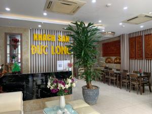 a restaurant with a palm tree in a lobby at Duc Long Hotel in Hanoi