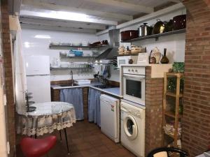 a kitchen with a stove and a washing machine at La Casa del Muti in Campanario