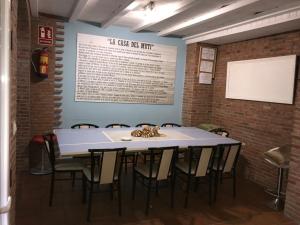 a table and chairs in a room with a sign on the wall at La Casa del Muti in Campanario
