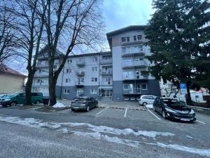 a parking lot with cars parked in front of a building at Apartmán Rajecké Teplice in Žilina