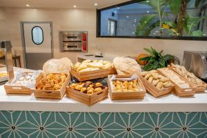 a table with baskets of bread and other foods at Checkin Bungalows Atlántida in Los Cristianos
