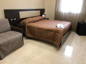 a bedroom with a large bed and a chair at Grand Hotel Royal in Pompei