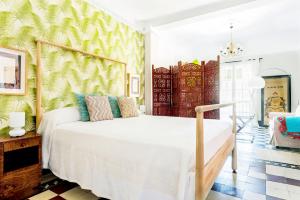 a bedroom with a white bed and a green wall at Genteel Home Romanilla in Granada