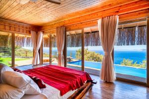 a bedroom with a bed with a view of the ocean at Heaven Resort Faralya in Faralya