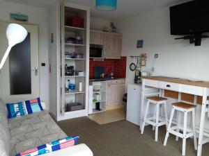 a living room with a kitchen with a counter and a table at studio résidence le sombreuil in Quiberon