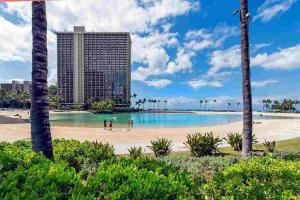 a beach with palm trees and buildings in the background at Ilikai Marina Studio City View Condos with Fully Equipped Kitchens & Free Wifi in Honolulu