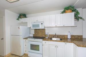 a kitchen with white cabinets and white appliances at Ilikai Marina Studio City View Condos with Fully Equipped Kitchens & Free Wifi in Honolulu +16 photos