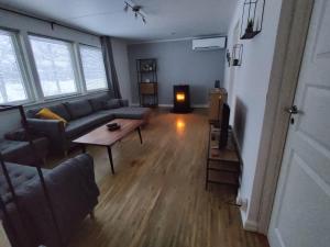 - un salon avec un canapé, une table et une télévision dans l'établissement Villa Stolle, à Hammarstrand