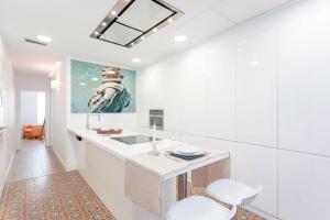 a white bathroom with a sink and a mirror at Genteel Home Julio César in Seville