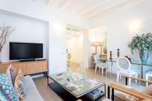 a living room with a couch and a tv at Genteel Home Julio César in Seville