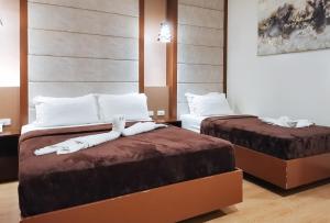 twee bedden in een hotelkamer met handdoeken erop bij RedDoorz Premium @ GRAND 29 Hotel in Dumarao
