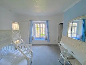 a bedroom with a bunk bed and two windows at The Retreat @ The Old Smithy, Colebrook Village in Plymouth