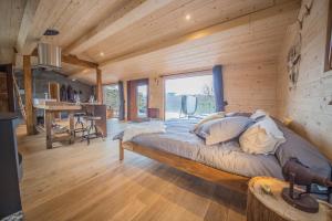 ein Schlafzimmer mit einem Bett in einer Holzhütte in der Unterkunft Le Fruit du Chêne in Hamoir