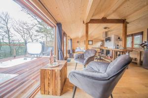 a living room with two chairs and a table at Le Fruit du Chêne in Hamoir