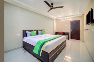 a bedroom with a bed with a ceiling fan at Staro Hotel - Hotel in Vijayawada in Vijayawāda