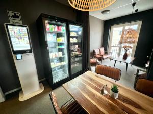 een kamer met een koelkast en een houten tafel bij Hotell Siesta in Karlskrona