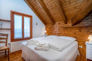 a bedroom with a bed with towels on it at Panoramic House Carnia - Mountain View APT with Parking and Terraces in Ligosullo