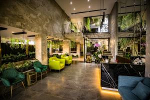 a lobby with yellow chairs and plants at Fati Boutique Hotel & Apartment in Vung Tau