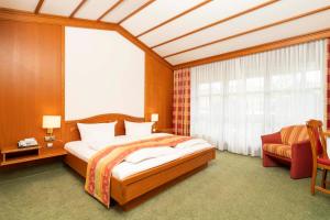 a bedroom with a bed and a large window at Hotel Brauerei Gasthof Höhn in Memmelsdorf