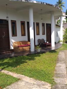 a front porch of a house with a couch at Villa Sunrise in Induruwa
