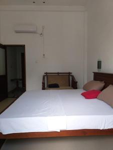 a bedroom with a large white bed in a room at Villa Sunrise in Induruwa