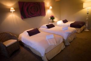 um quarto de hotel com duas camas com lençóis brancos em Hôtel Quai des Pontis em Cognac