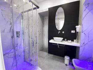 a purple bathroom with a sink and a shower at Aurora Luxury Rooms in Naples