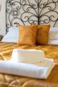 a bed with a metal headboard and pillows on it at Relais Accademia in Florence