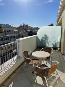a balcony with a table and chairs on a roof at Athens Mirabello in Athens