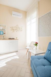 un soggiorno con divano blu e tavolo di Residence Appartamenti Santa Teresa a Chiaia a Napoli