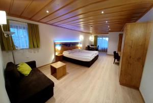 ein Schlafzimmer mit einem Bett und einer Couch in einem Zimmer in der Unterkunft Gästehaus Gritscher in Josefsthal
