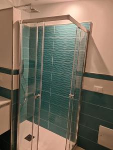 a shower in a bathroom with green tiles at Blue B&B in Formia