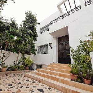 a white house with stairs leading to a door at Rooms To book in Villa House at HostFamily in Rabat in Rabat