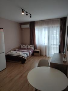 um quarto com uma cama e uma mesa branca em Studio 16A Vasil Aprilov 64 - Plovdiv em Plovdiv